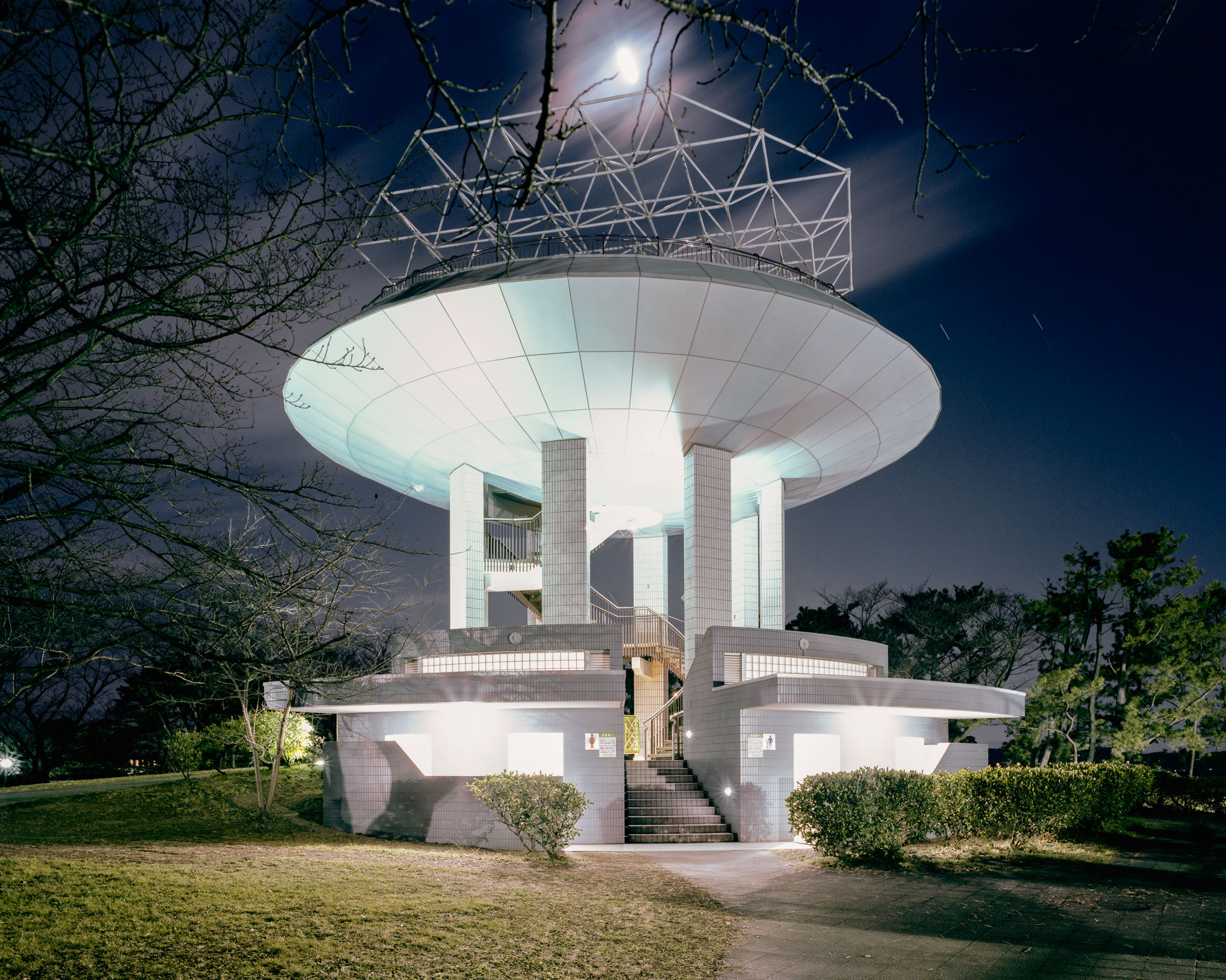 Tall circular public toilet building with a broad disc-shaped roof