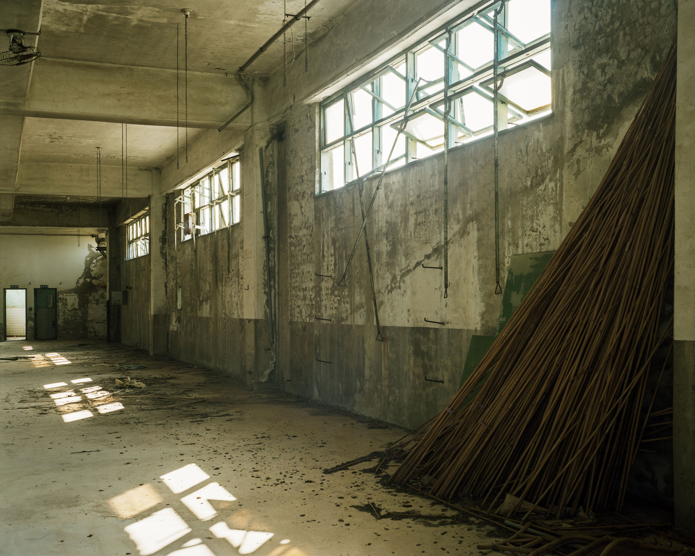 Bundle of metal rods leaning in a long hall with broken windows