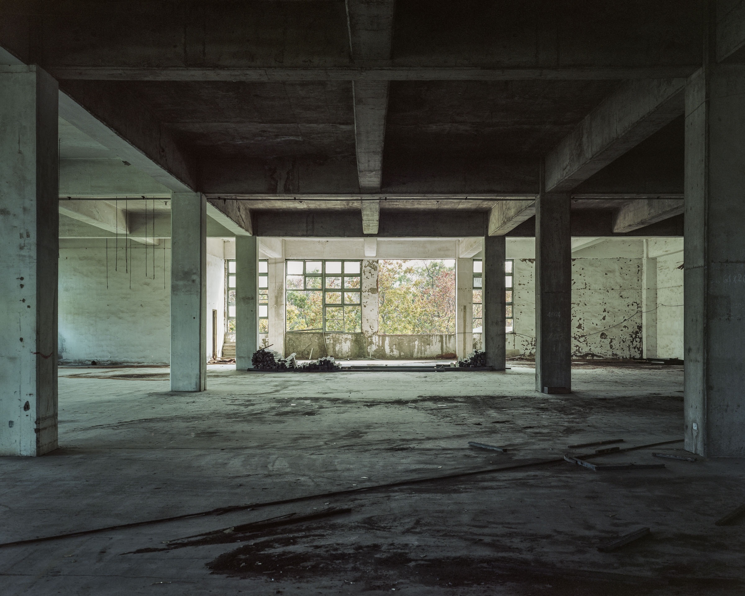 Empty concrete factory floor divided by columns and open windows