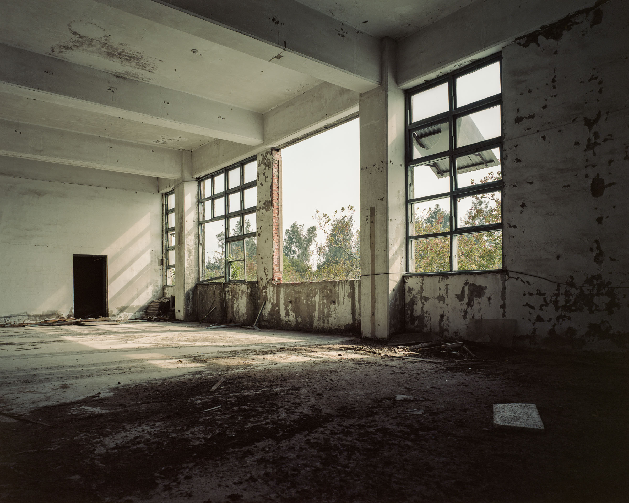 Empty factory room with peeling walls and open windows